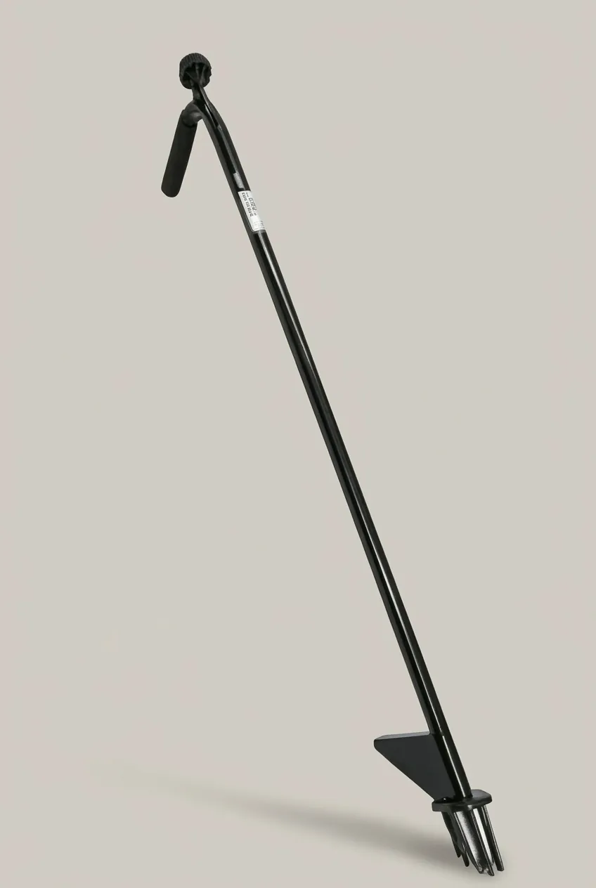 The Weed Hound stand-up weed puller photographed on a plain neutral studio background, showing its single-side angled grip, steel shaft, triangular step bar and six steel tines