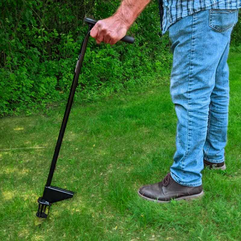 The Weed Hound stand-up weed puller standing upright on a green lawn